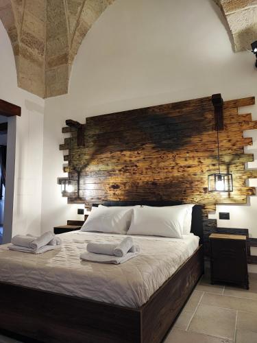 a bedroom with a large bed with a wooden headboard at Loft Porta Sud Civ.33 in Brindisi