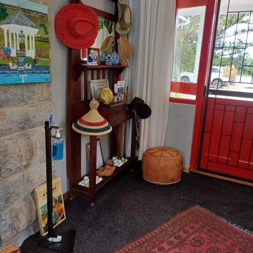 a room with a red door and a hat on a shelf at Mulligans Guest Lodge in Hermanus