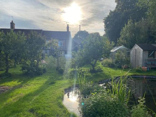 a view of a house with a pond in a yard at Charming artist’s cottage in East Knoyle