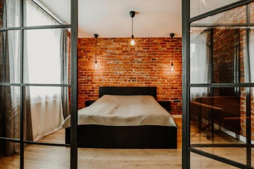 a bedroom with a bed and a brick wall at Old brick boutique apartments in Klaipėda