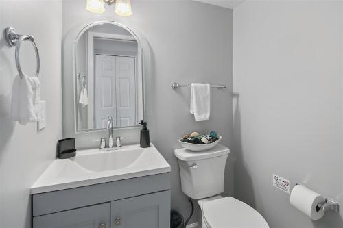 a bathroom with a sink and a toilet and a mirror at Townhome in No VA, Family Community, Pet Friendly, Fast WiFi in Sterling