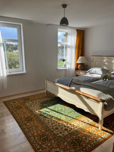 a bedroom with a large bed and a rug at Pie Jūras Pāvilostā in Pāvilosta