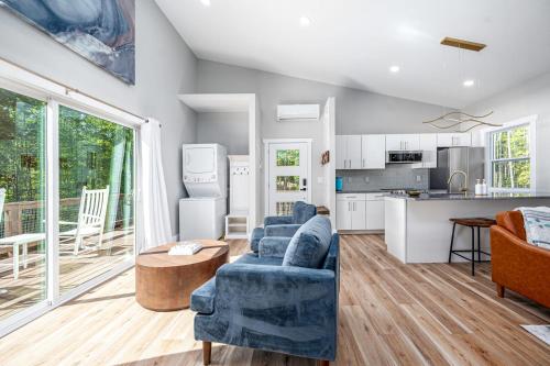 un soggiorno con divano blu e una cucina di New H2O Oasis Tree House a Pittsboro