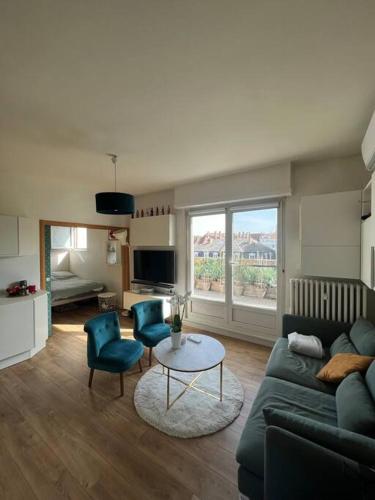 un salon avec un canapé, deux chaises et une table dans l'établissement Appartement cosy orangerie, à Strasbourg