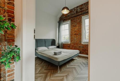 a bedroom with a bed and a brick wall at Old brick boutique apartments in Klaipėda