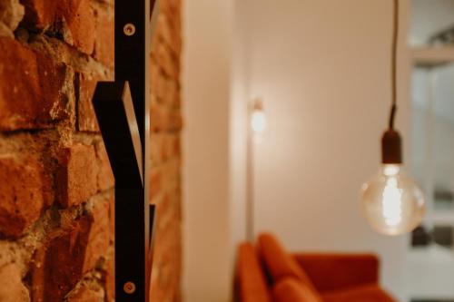 a room with a brick wall and a light fixture at Old brick boutique apartments in Klaipėda