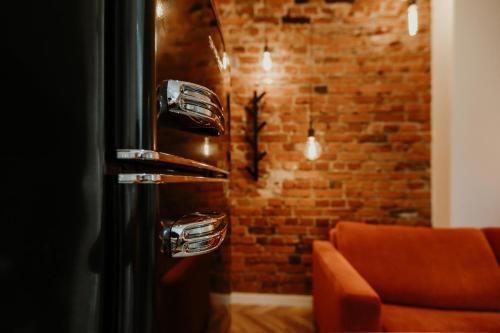 a black refrigerator in a room with a brick wall at Old brick boutique apartments in Klaipėda