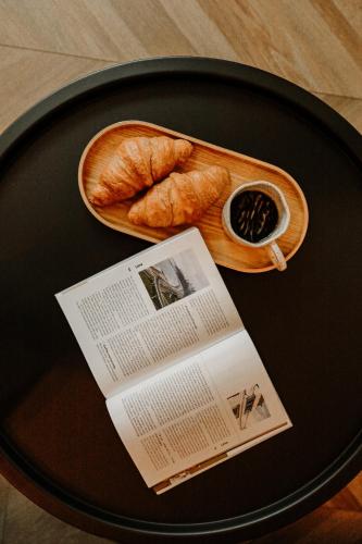 a table with a plate of bread and a newspaper at Old brick boutique apartments in Klaipėda