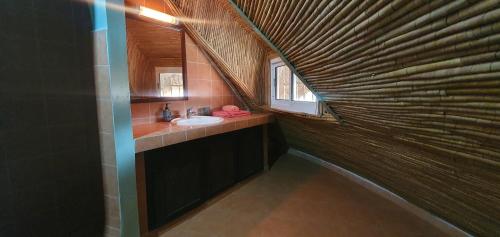 uma casa de banho com um lavatório e um espelho em Villa bord de mer avec piscine em Sali Tapé