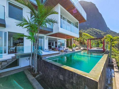 an exterior view of a house with a swimming pool at Linda casa no Joá, com vista incrível do mar do Rio in Rio de Janeiro
