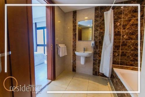 a bathroom with a shower and a sink and a tub at luxury apartments in cairo , porto new cairo , nyum in Cairo
