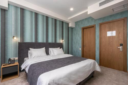 um quarto com uma cama grande e uma porta de madeira em Brooch Boutique Hotel em Tbilisi