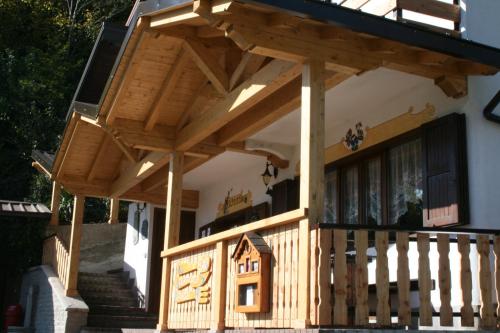 una casa de madera con techo en el lateral de un edificio en B&B Navertino, en Borno