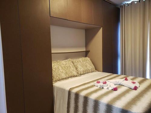 ein Schlafzimmer mit einem Bett mit zwei Puppen drauf in der Unterkunft Apartamento moderno, equipado e confortável in Porto De Galinhas