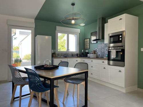 Il comprend une cuisine avec une table et des chaises en bois. dans l'établissement * Domaine de la Solaie * - Proche Bords de Loire, à Saint-Denis-de-l'Hôtel