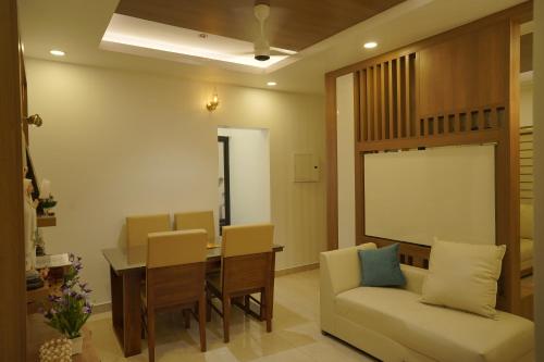 a living room with a table and chairs and a couch at Luxury Homes - Cochin Airport - Nedumbassery in Angamaly
