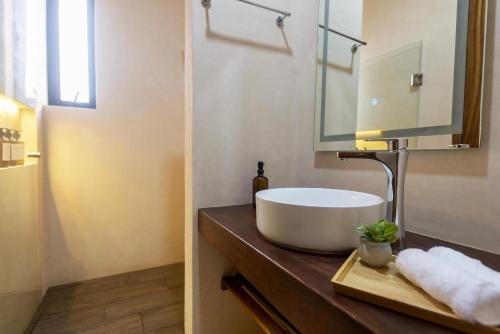 Un baño con un lavabo blanco y un espejo. en Casa Ita Surf - Adults Only, en Puerto Escondido