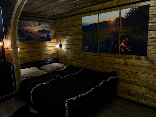 - une chambre avec un lit dans une cabane en rondins dans l'établissement LINDEN GROVE, à Vygoda
