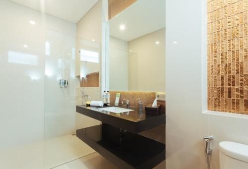 a bathroom with a sink and a mirror at The Arnaya in Kuta