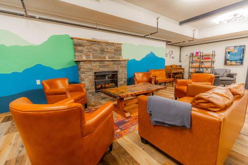 a living room with orange chairs and a fireplace at Pintler's Portal Hostel in Anaconda