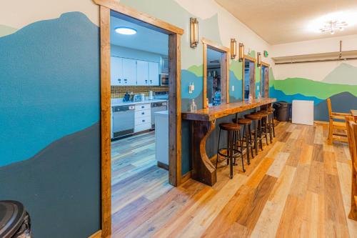 a kitchen with a bar with stools at Pintler's Portal Hostel in Anaconda