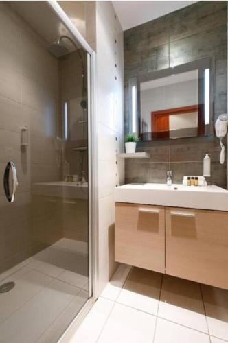 une salle de bain avec une douche, un lavabo et un miroir dans l'établissement Centre ville à 5 mn à pied du Palais et plages, à Cannes