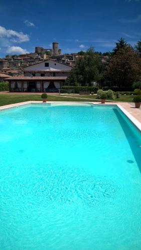 a large blue swimming pool with a building in the background at Il Casale di Riardo Luxury B&B in Riardo