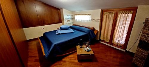 a bedroom with a blue bed and a table at La Rosa dei Venti Guest House in Pontecagnano