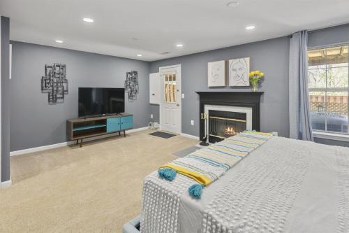 a bedroom with a bed and a tv and a fireplace at Cozy 4BR Townhome, Family Community, 40 Mins to DC in Sterling