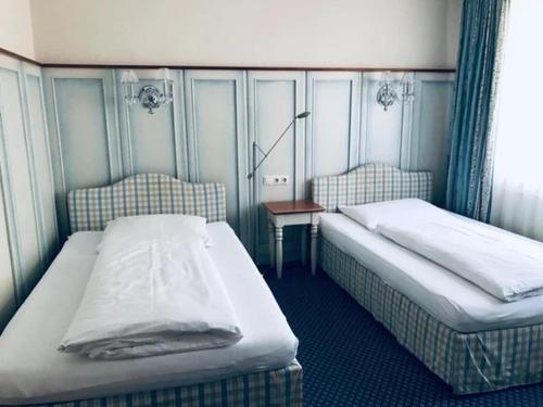 Zimmer mit 2 Betten und einem Tisch in der Unterkunft Hotel Daneu Gaschurn in Gaschurn