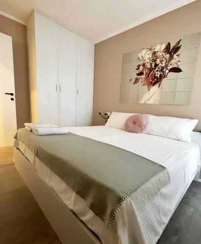 a bedroom with a large bed with a painting on the wall at 7 SKY UDINE in Udine