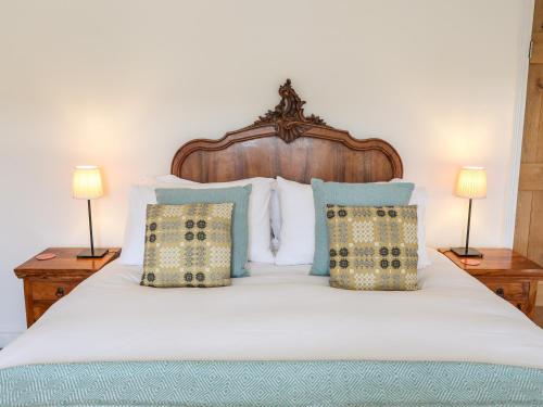 a bedroom with a large white bed with two lamps at Shamrock Cottage in Conwy
