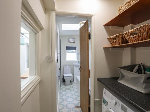 a small bathroom with a toilet and a sink at Shamrock Cottage in Conwy