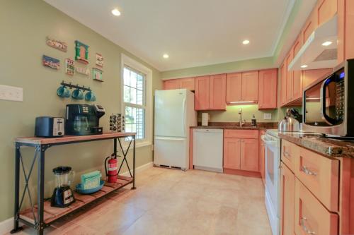 una cucina con armadi rossi e frigorifero bianco di NEW! 3-story Townhome - Private, Self checkin, Quiet. a Sterling