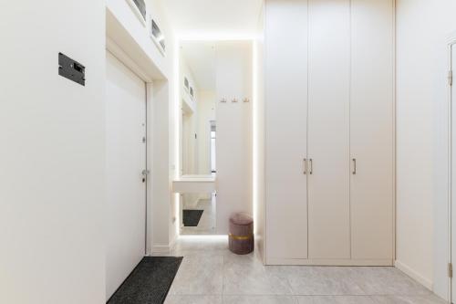 biały korytarz z białymi szafkami i drzwiami w obiekcie Luxury Apartments “Dream City” w mieście Użhorod