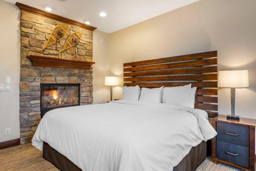 a bedroom with a large bed and a fireplace at Bluegreen Vacations Big Bear Village, Ascend Resort Collection in Big Bear Lake