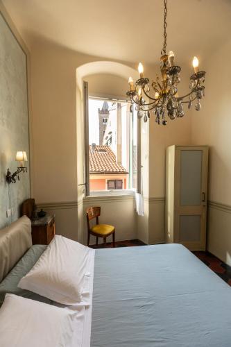 una camera da letto con un letto bianco e una finestra di Casa Giangarè a Sarzana
