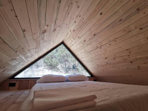 uma cama num quarto com uma grande janela em Bosques del Cielo em Los Lirios