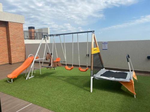 a playground with swings on a roof at Confortable apto. en Asunción. in Luque