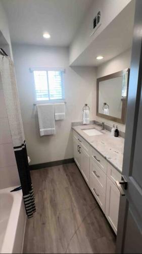 uma casa de banho com um lavatório e um espelho em Houston Hideout Sleek 1-BR Apt Urban Haven em Houston