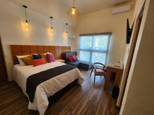 1 dormitorio con cama, escritorio y ventana en Hotel Consulado Petite Gallerie, en Guadalajara