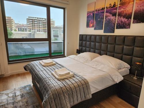 a bedroom with a large bed and a large window at Ramonda Belgrade Waterfront - BW Aqua in Belgrade