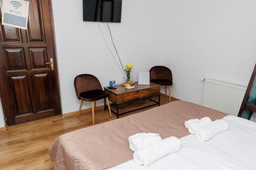 a bedroom with a bed and two chairs and a table at Casa Iager - Vama Buzaului in Acriş