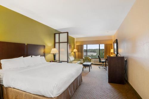 um quarto de hotel com uma cama grande e uma sala de estar em Antioch Hotel & Suites em Antioch