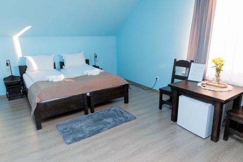 a bedroom with a bed and a desk and a table at Casa Iager - Vama Buzaului in Acriş