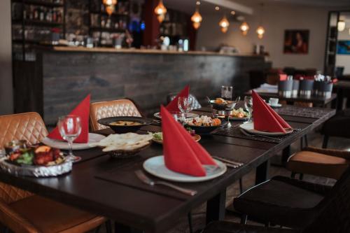 a table with plates of food and wine glasses at Hotel Lindenhof in Erkelenz