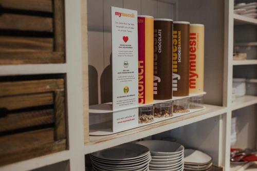 a book shelf with books and plates on it at Hotel Lindenhof in Erkelenz
