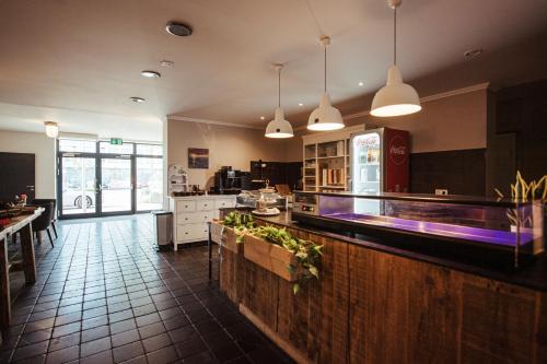 a large kitchen with a counter and a restaurant at Hotel Lindenhof in Erkelenz