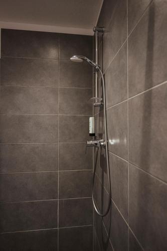 a shower with a shower head in a bathroom at Hotel Lindenhof in Erkelenz