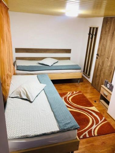 a room with two beds and a rug at Cabana Harghita Băi in Harghita-Băi
